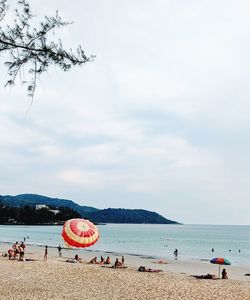 People on beach against sky