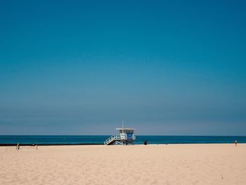 Scenic view of beach against blue sky