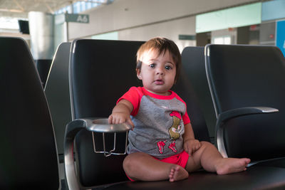 Portrait of cute girl sitting on seat