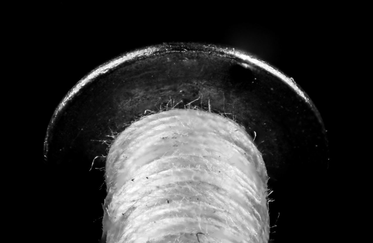 LOW ANGLE VIEW OF ILLUMINATED LIGHT BULB AGAINST BLACK BACKGROUND
