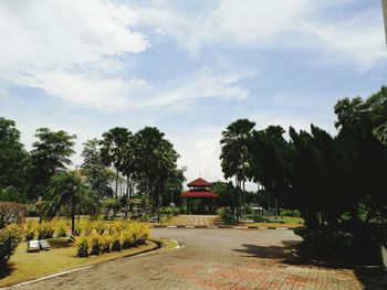 View of trees and buildings against cloudy sky