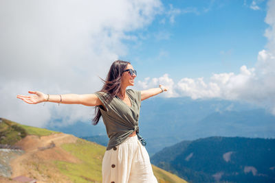 Young woman standing against mountain