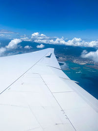 Airplane flying over clouds against blue sky