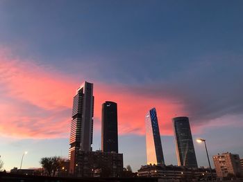 Low angle view of modern buildings against sky during sunset