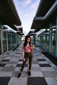 Portrait of woman standing on footpath