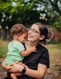 Smiling mother and son sitting outdoors