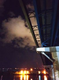 Low angle view of illuminated bridge against sky at night