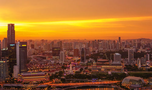 Aerial view of city lit up at sunset