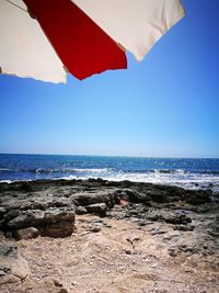 Scenic view of beach against clear blue sky