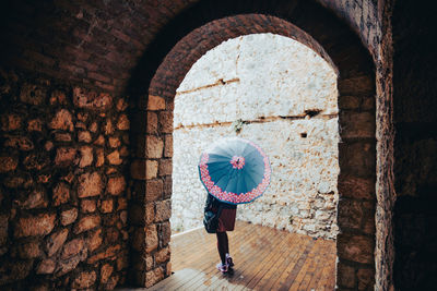 Rear view of woman standing in tunnel