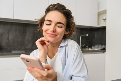 Young woman using mobile phone at home