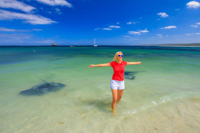 Woman with arms outstretched standing in sea