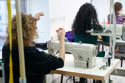 Rear view of fashion designers working at workshop