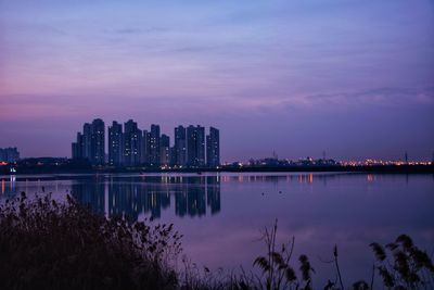Reflection of buildings in lake at dawn