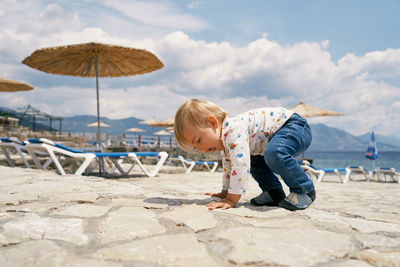 Boy on beach against sky