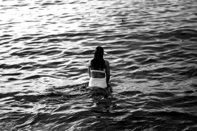 Rear view of woman swimming in sea