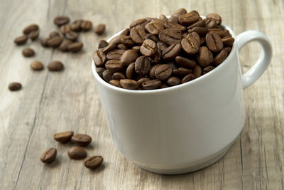 Close-up of coffee beans in mug on table