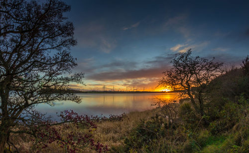 Scenic view of lake against sky at sunset