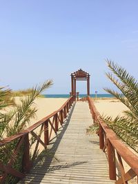 Pier over sea against clear blue sky