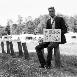 Full length of man sitting on field