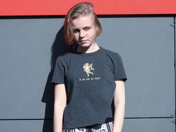 Portrait of beautiful woman standing against wall