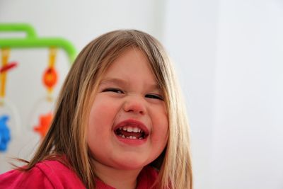 Close-up portrait of smiling girl at home