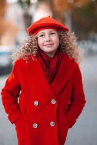 Portrait of young woman standing against trees