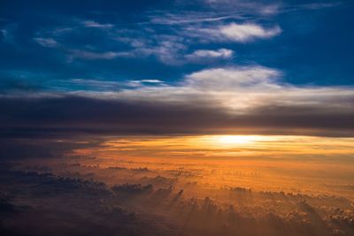 Aerial view of clouds over landscape during sunset