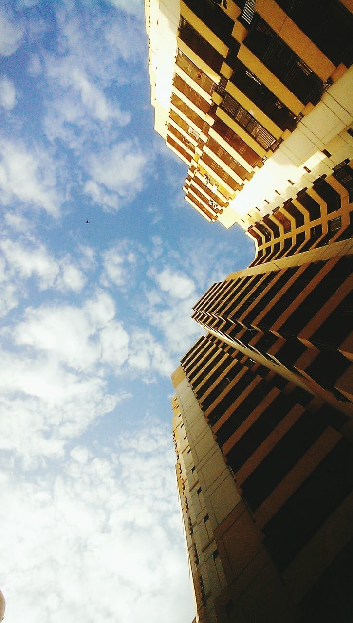 architecture, building exterior, built structure, low angle view, skyscraper, tall - high, city, tower, office building, sky, modern, building, tall, directly below, cloud - sky, day, outdoors, city life, cloud, no people