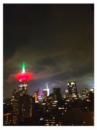 Illuminated cityscape against sky at night