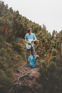 Full length of man with flowers and trees against sky
