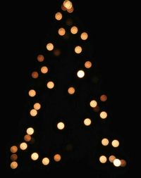 Illuminated candles against black background