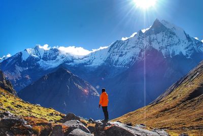 Man standing against snowcapped mountains