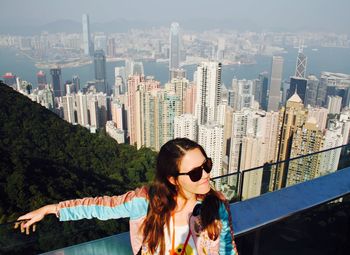 High angle view of woman against skyscrapers at victoria harbour