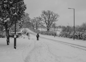 Man walking on snow covered road