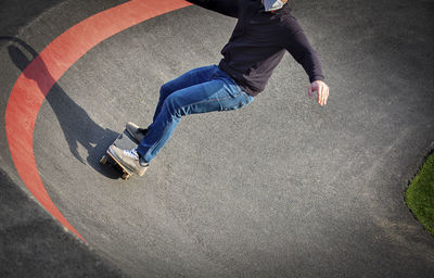 Low section of man skateboarding on street