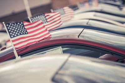 Close-up of american flags on cars