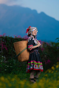 Woman with umbrella standing on field