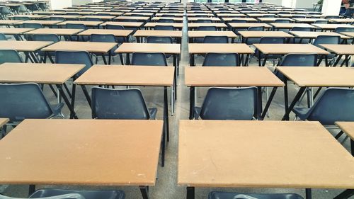 Empty chairs and tables arranged in classroom