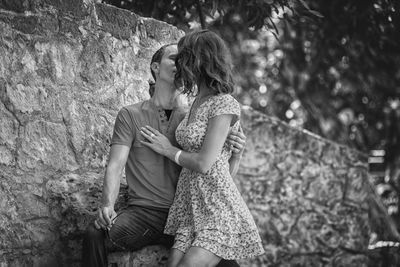Couple kissing while standing against wall