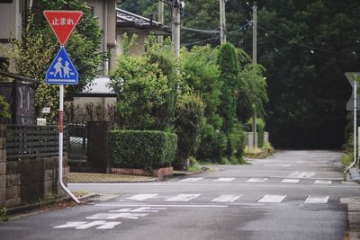 Empty road with trees in background