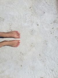 Low section of woman standing on beach