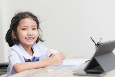 Girl using digital tablet at table