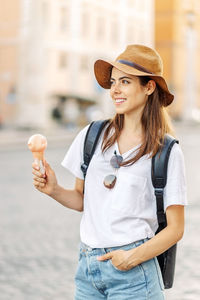 Young woman wearing hat standing at beach