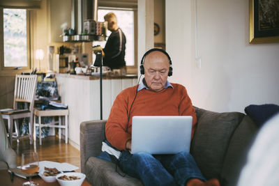 Senior gay man using laptop while sitting at home
