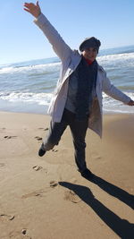 Full length of smiling young woman on beach