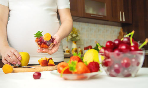 Pregnant woman preparing fruit salad