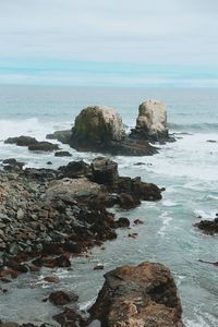 Rock formation on beach against sky