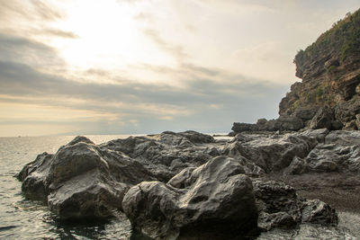 Rock formations by sea against sky