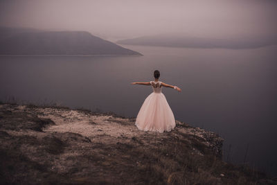 Rear view of woman standing on rock